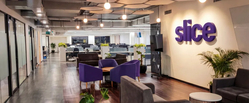 Slice office lounge with purple sofas and the slice logo on the wall